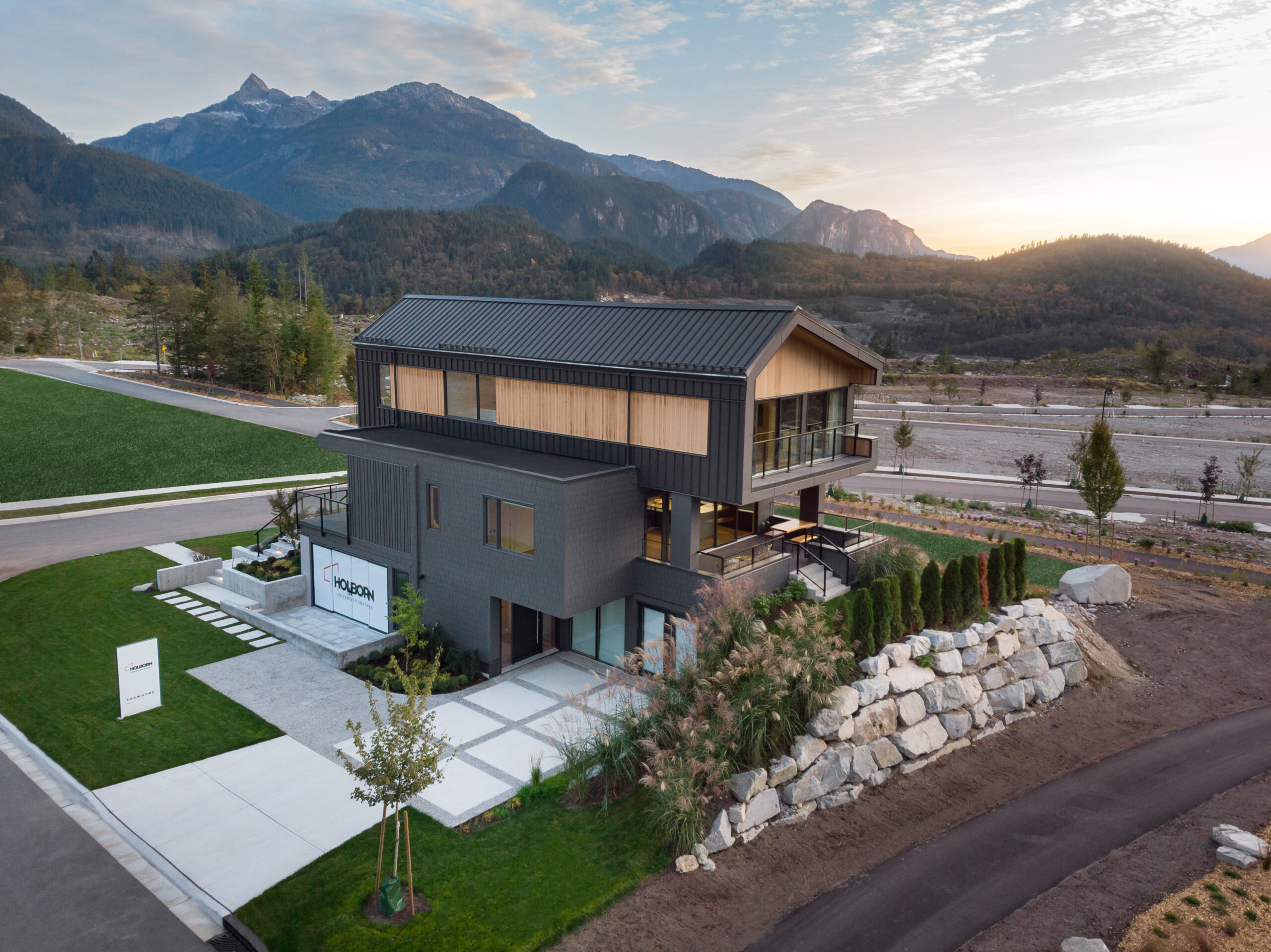 Aerial View of Dark Exterior Show Home and Mountain Range in background