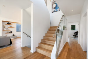 Picture of central staircase with wood flooring to contrast walls and metal railings with clear glass